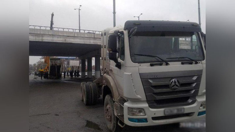 Изрображение 'Неудобное положение: водитель грузовика не смог проскочить под мостом в Ташкенте (фото)'