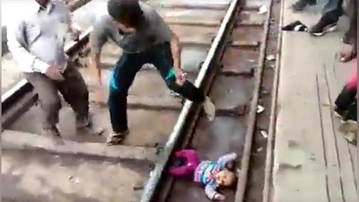 Изрображение 'ЧУДОМ СПАСЛАСЬ: МАЛЫШКУ В ИНДИИ УРОНИЛИ ПОД ПОЕЗД (ВИДЕО)'