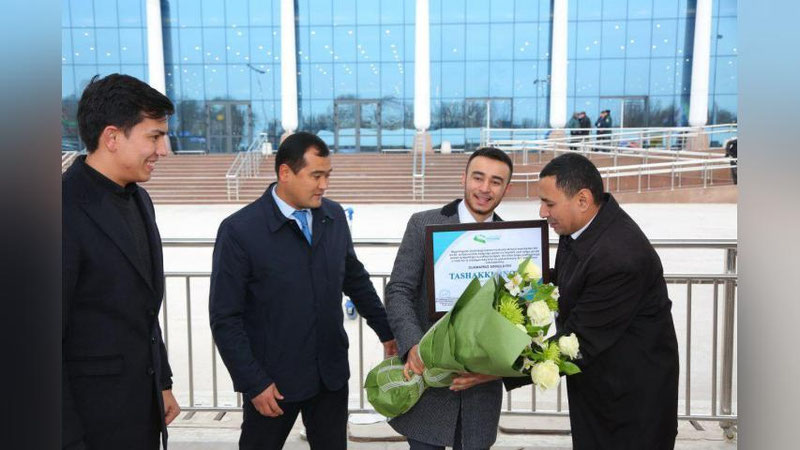 'Rossiyada qahramonlik ko`rsatgan o`zbekistonlik yigit Toshkent Xalqaro aeroportida kutib olindi'ning rasmi