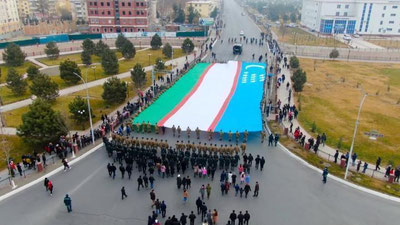 Изрображение 'Гигантский флаг Узбекистана пронесли по улицам Ферганы (фото, видео)'