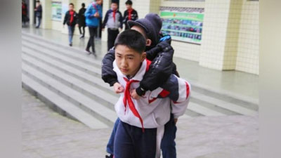 '12 yoshli bola 6 yildan beri nogiron do`stini elkasida maktabga ko`tarib olib boradi 'ning rasmi