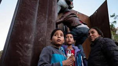 'Markaziy Amerikalik muhojirlar chegaradagi devorga chiqib olishdi'ning rasmi