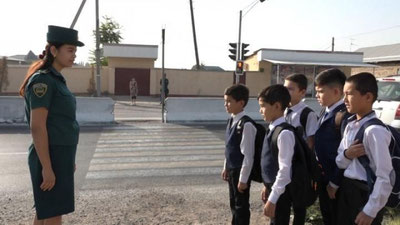 'Ayol inspektorlar o`quvchilarining yo`ldan o`tishiga ko`maklashmoqda'ning rasmi