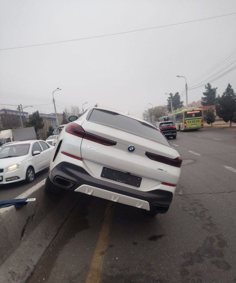 Изрображение 'В Сергели автомобиль BMW повис на разделительном бордюре'